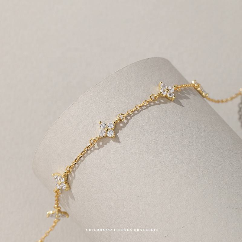 Gold bracelet with floral designs on a neutral background