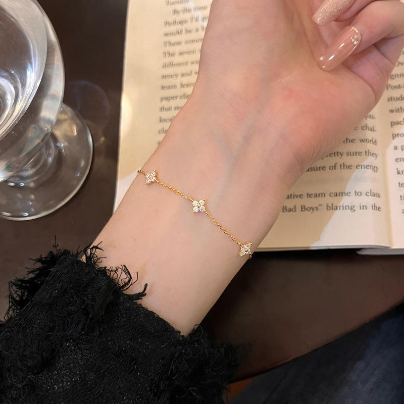 Gold bracelet on a wrist with an open book in the background