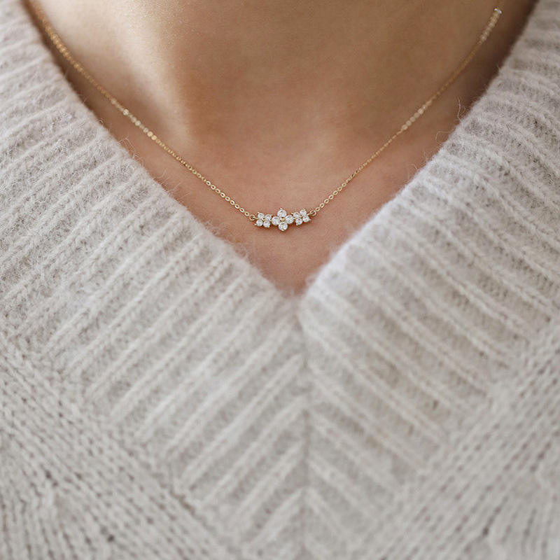 Necklace with small diamonds on a person wearing a light gray sweater