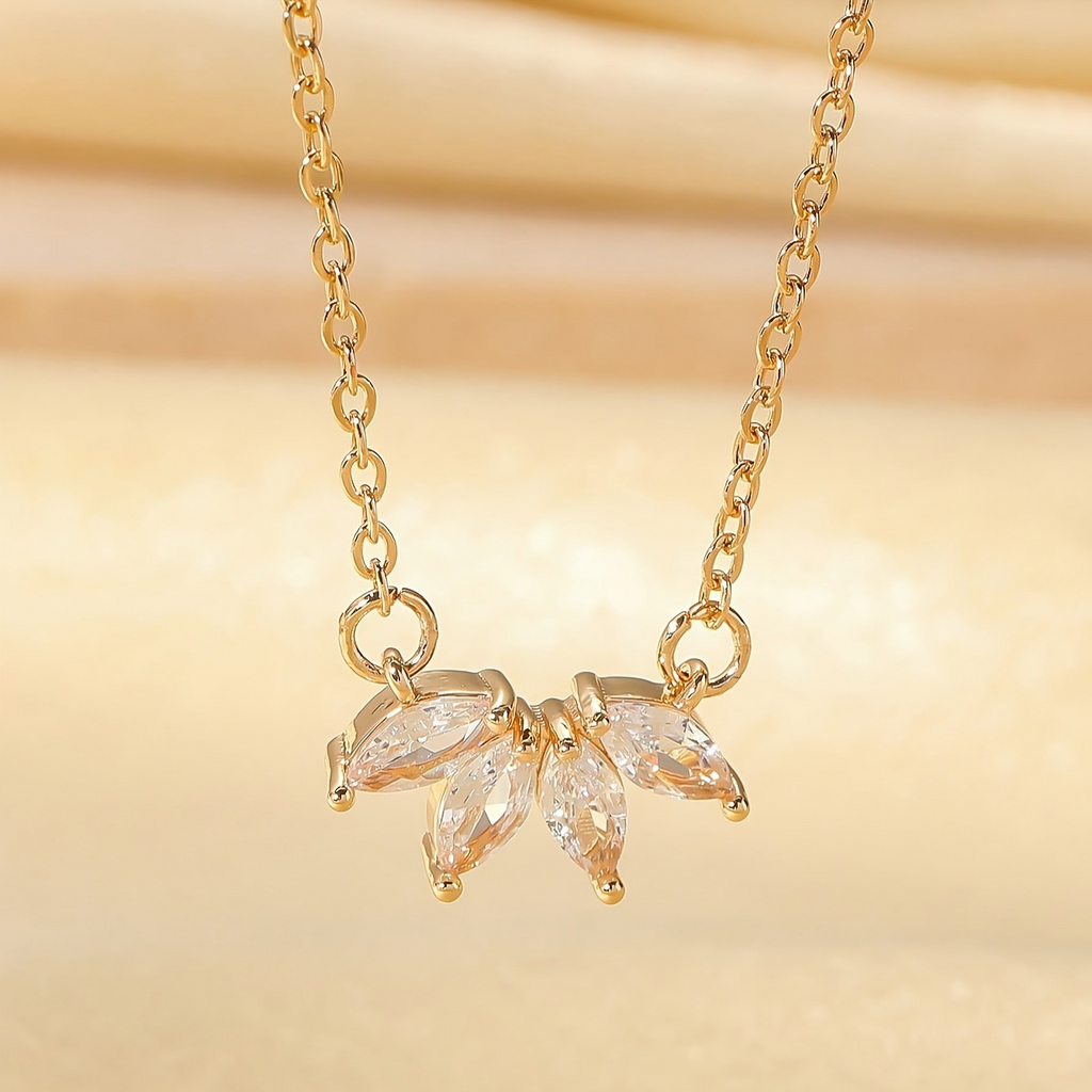 Gold necklace with leaf-shaped pendant on a gold background