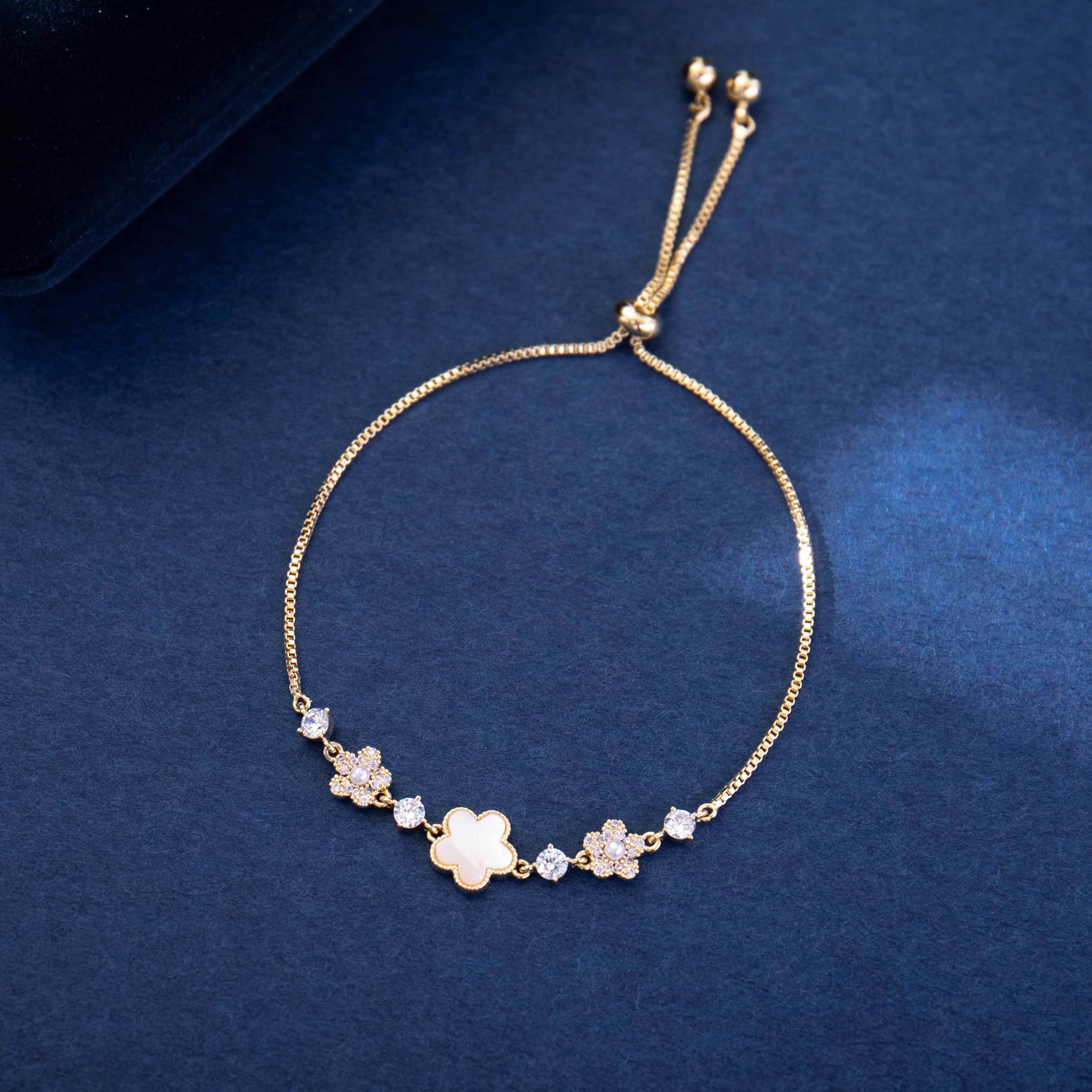Gold bracelet with floral designs on a blue background