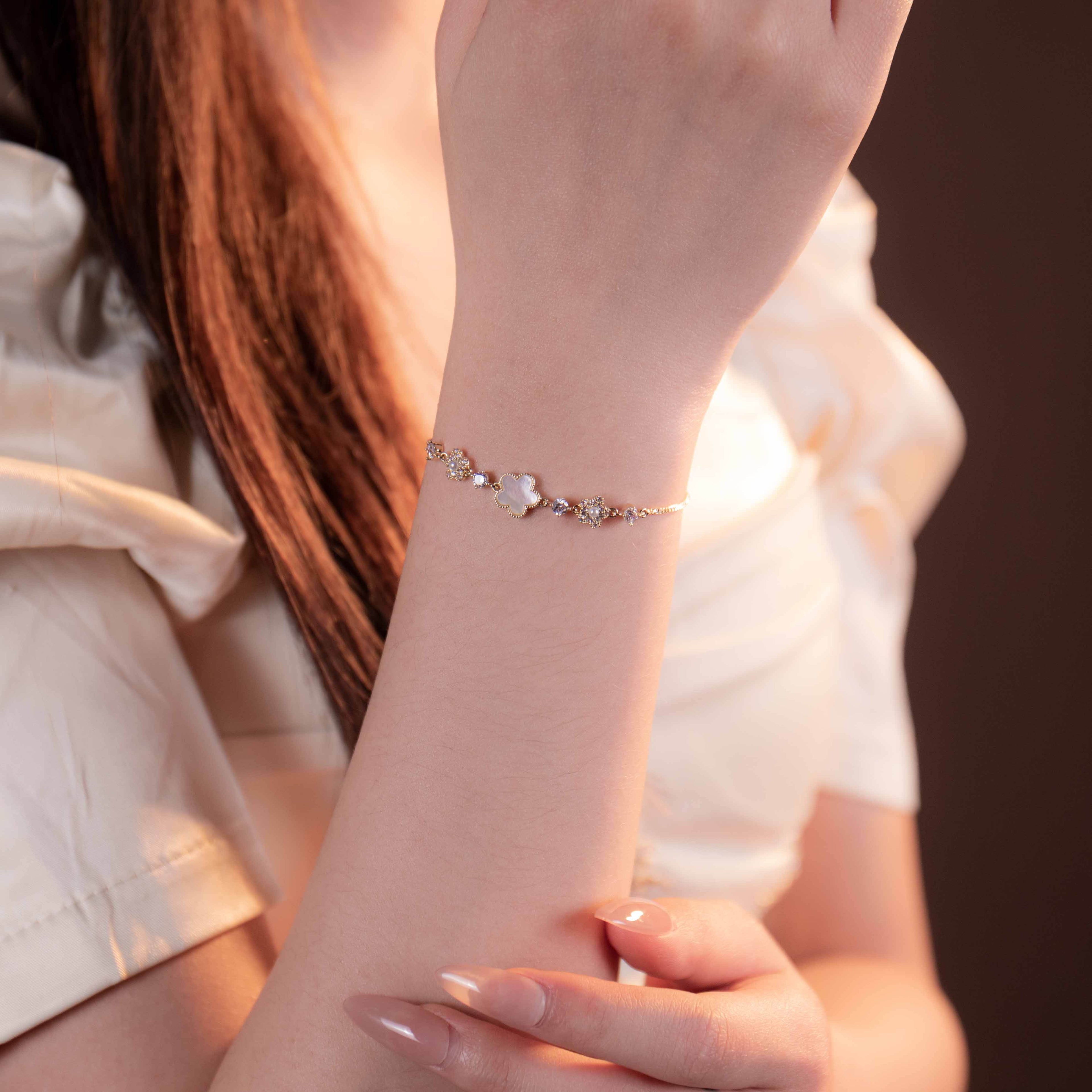 Close-up of a person wearing a delicate bracelet on a blurred background