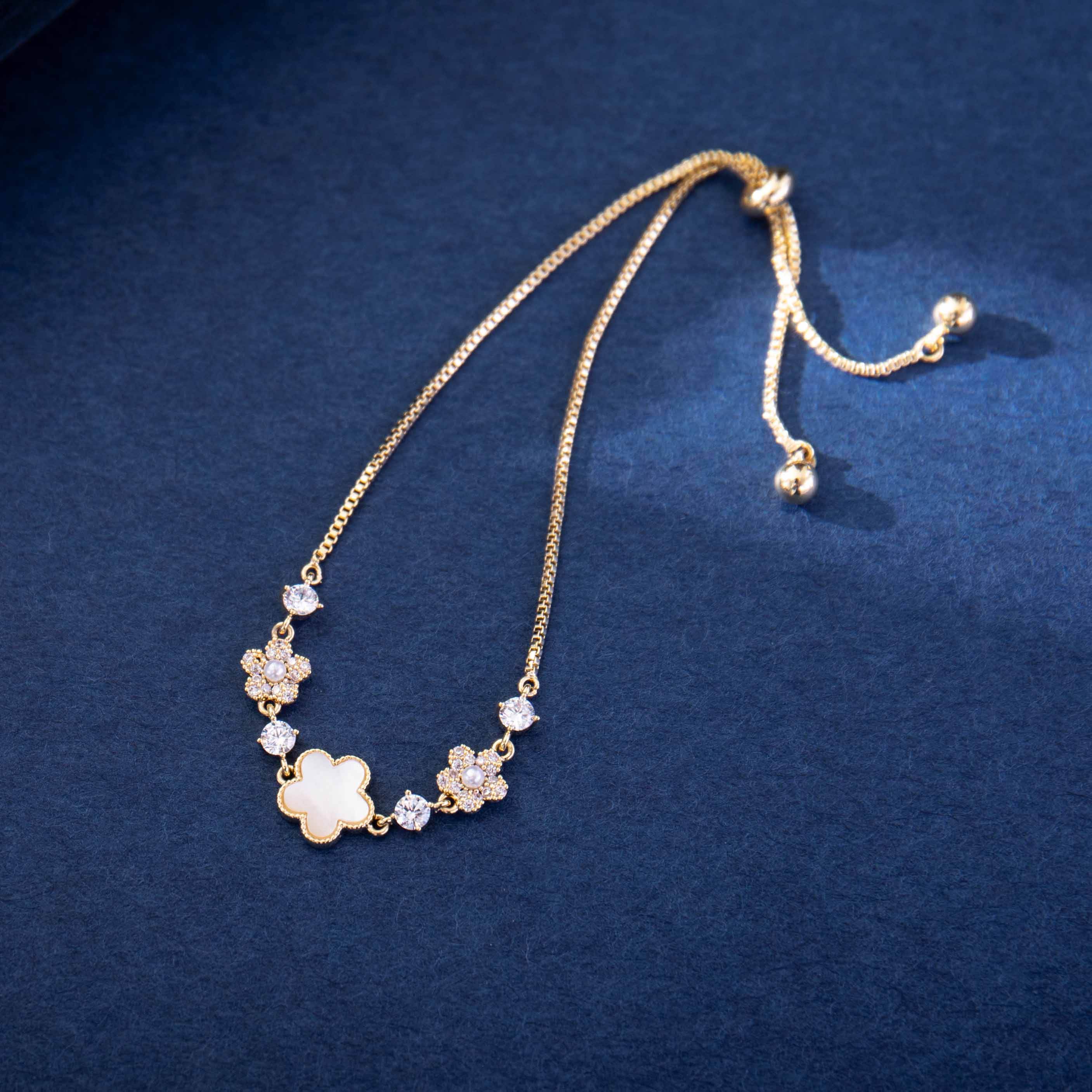Gold necklace with floral designs on a blue background